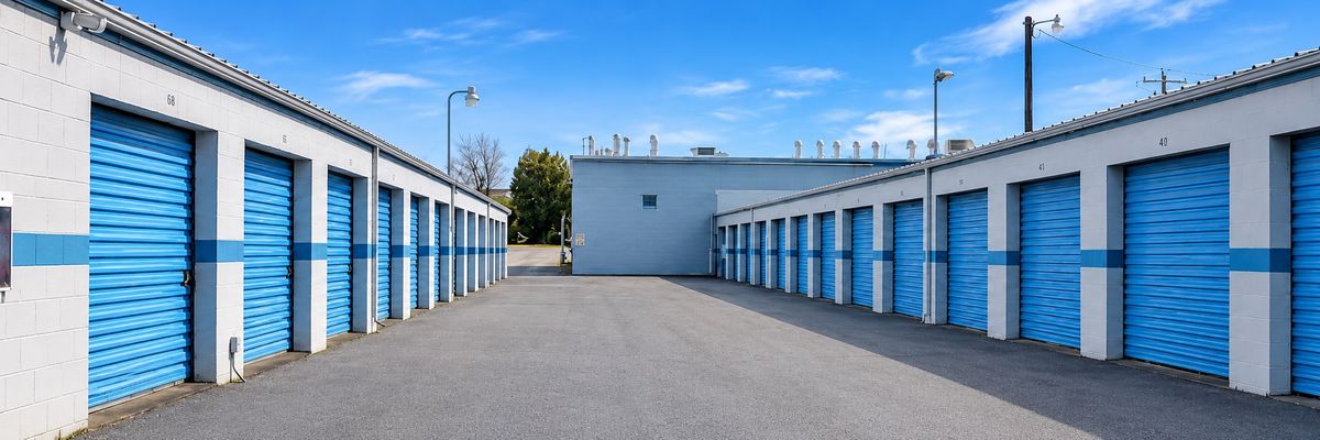 Blue storage doors on both sides of the paved drive-up aisle at Isaacs Mini Storage in Walla Walla